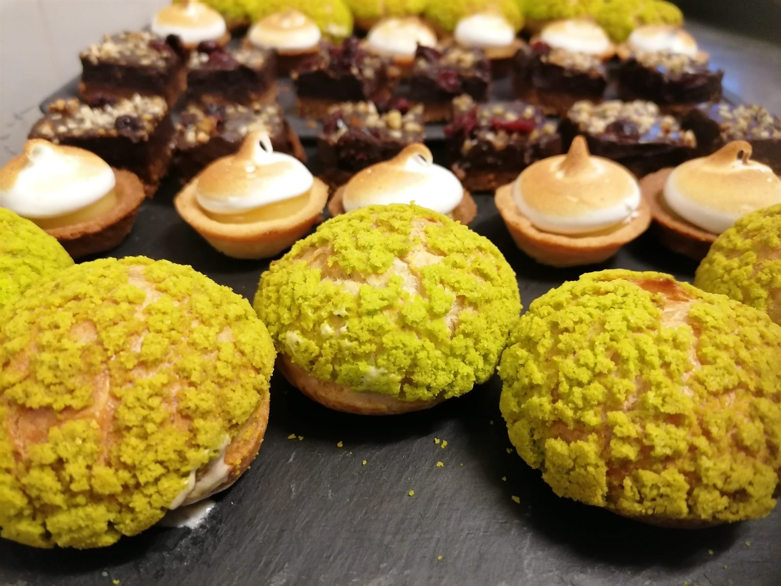 Un plateau de choux craquelin pistache, tartelettes meringuées et brownies